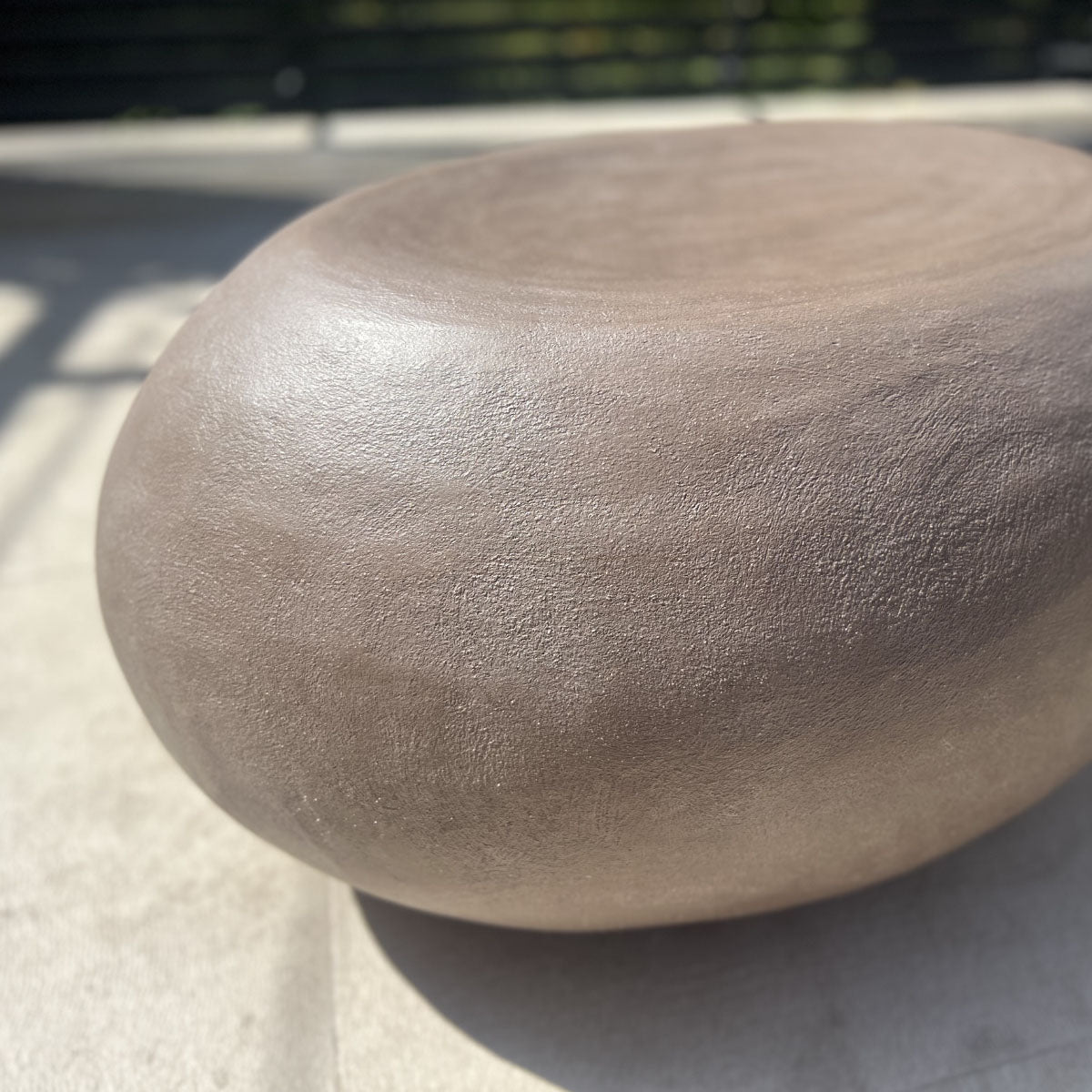 Pierre de jardin géante en béton utilisée comme pouf